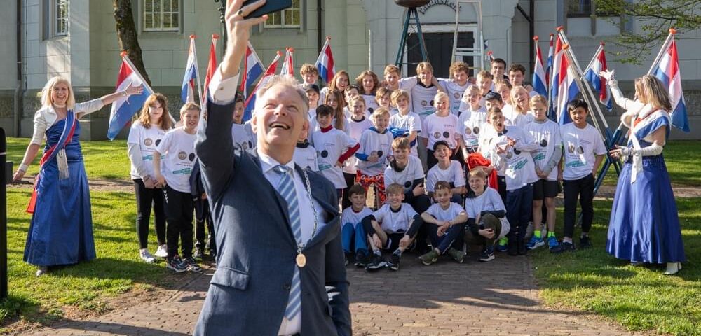 Burgemeester Röell maakt een selfie met lopers van de Bevrijdingsloop, 2023