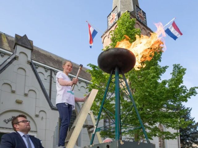 Gwen Scheel (11) steekt in 2025 het bevrijdingsvuur aan op de Brink in Baarn. Foto: Caspar Huurdeman